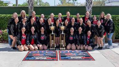 varsity and jv warriorettes outside with trophies