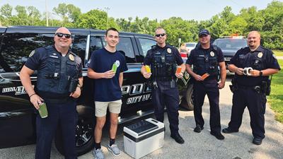 From left, Arnold Police Officer Josh Lambrich, Arnold Police Explorer Brayden Belding, and officers Kevin Wilson, Josh Crites and Mike Prusinowski handed out free popsicles on June 11 at Arnold City Park.