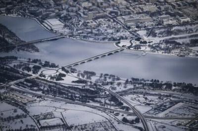 This aerial view shows a snow-covered Washington, DC, including the Lincoln Monument, the Kennedy Center, the Potomac River and the National Mall from Air Force One