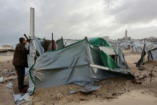 A displaced Palestinian fixes a tent in Gaza City