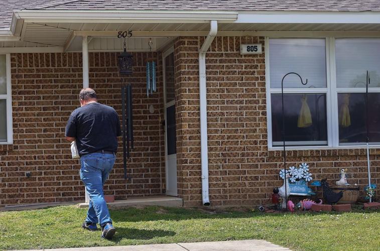 Chris Clubbs walks up to a patient’s house to deliver medication
