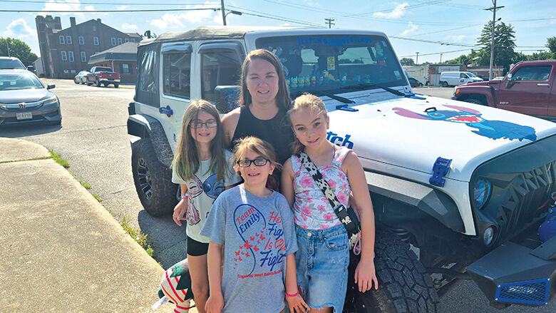 Amber White, back, with her daughters, from left, Danielle, 9; Peyton, 7; and Emily, 10, by her Jeep.