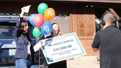 Danielle Lam of Publishers Clearing House, left, and Angela Schulze celebrate after Schulze was awarded $25,000.