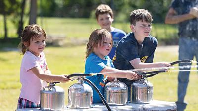 From left, Savannah Hall, 4, of Dittmer; Paisley Hall, 5, of Dittmer; and Evan Griffith, 12, of Cedar Hill take part in a fire extinguisher demonstration at the Cedar Hill Fire Protection District’s 75th anniversary celebration on Sept. 6.