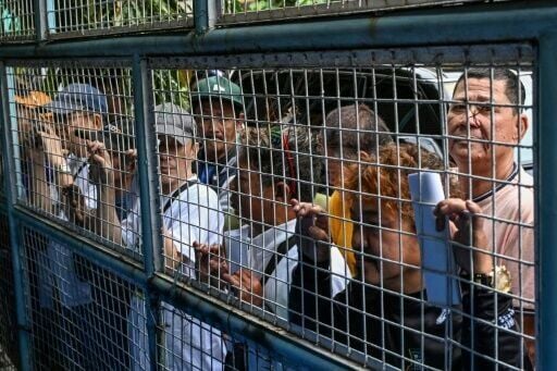 Tricycle drivers stand outside a Manila community centre on Monday as they await a 5,000 peso fuel subsidy from the government