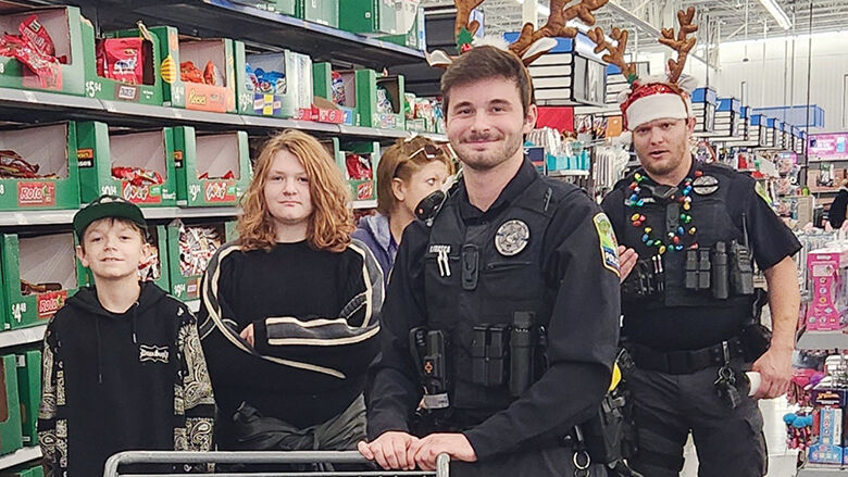 Officer Dominic Frasca, left, and Sgt. Cody Umfress help young shoppers at the Byrnes Mill Shop With a Hero event.