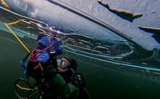 A participant in the Polar Scientific Diving programme takes ice samples during a 45-minute-long diving session