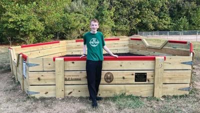 Colin Ashwell, a junior at Northwest High School, with his finished Eagle Scout project, a gaga ball pit at House Springs Elementary School