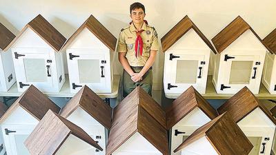 Karter Reese and some of the lending library boxes he built.