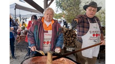 Nadine Garland and Greg Pfeiffer stir apple butter at the 2025 Apple Butter Festival.