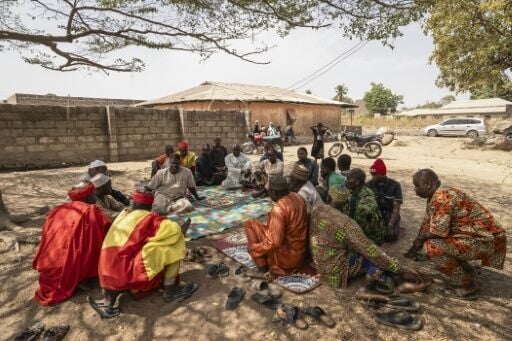 Residents who fled the massacre in the Nigerian village of Woro gather at the local chief's house in the neighbouring town of Kaiama