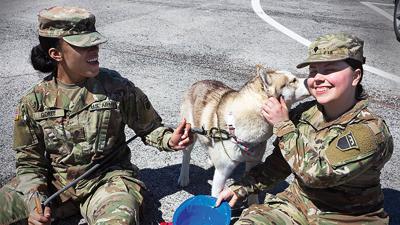 Zakija Goree tries to keep puppy Alaska from licking everyone silly at the 2022 parade.