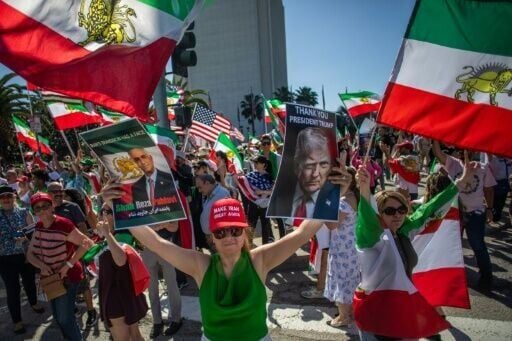 A woman holds pictures of Reza Pahlavi - the son of Iran's former Shah - and US President Donald Trump as members of the Iranian community celebrate in Los Angeles
