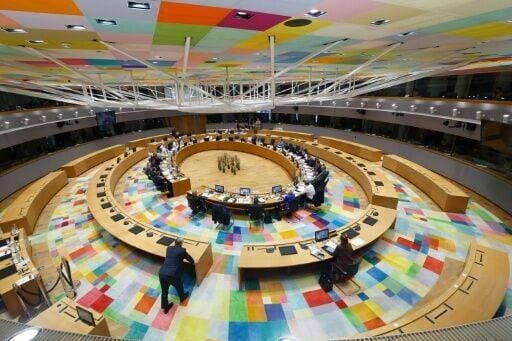Hungary's Viktor Orban stands in the foreground as Ukrainian President Volodymyr Zelensky addresses EU leaders by videolink