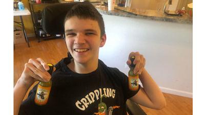 Drew Davis with bottles of his Crippling Hot Sauce.