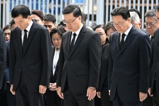 Hong Kong's Chief Executive John Lee (C) and other government officials observe three minutes of silence to mourn victims of the Wang Fuk Court residential estate fire