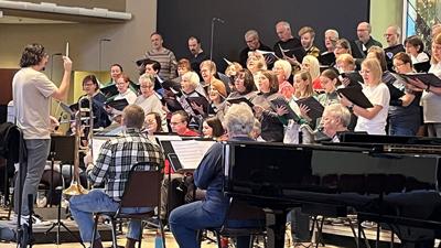 Adam Perez, St. John’s Lutheran Church director of music ministry, leads the choir and orchestra during rehearsal for this year’s Christmas production.