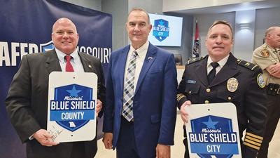 Jefferson County Sheriff Dave Marshak, left, Gov. Mike Kehoe, center, and Arnold Police Chief Brian Carroll celebrate Arnold and Jefferson County being the first communities to receive the Blue Shield designation during a ceremony April 24 at Arnold Cit...