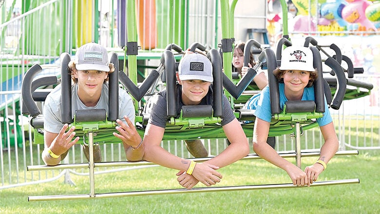From left, Drake Silhavy, Rylan Luttrell and Wade Conner, all from Hillsboro, and then 14, get ready to lift off on a carnival ride last year.