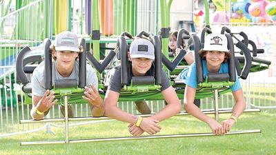 From left, Drake Silhavy, Rylan Luttrell and Wade Conner, all from Hillsboro, and then 14, get ready to lift off on a carnival ride last year.