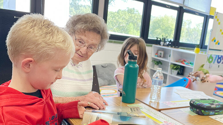 Jane Allen talks to first grader Eli Tubb about a book he picked out.