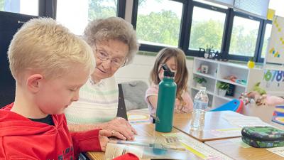 Jane Allen talks to first grader Eli Tubb about a book he picked out.