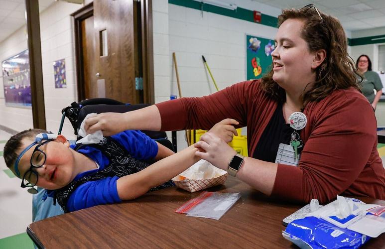 Carter, 11, turns his head away as Allison Peak, Carter’s DeafBlind Intervener