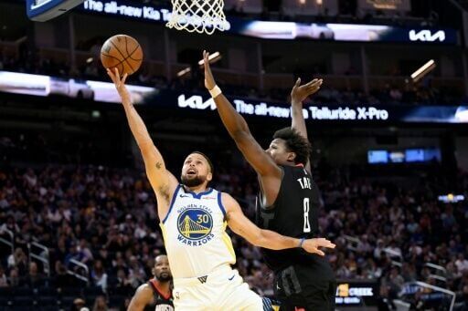 Golden State star Stephen Curry puts up a shot against Jae'Sean Tate in the Warriors' NBA loss to the Houston Rockets, Curry's first game since January 30