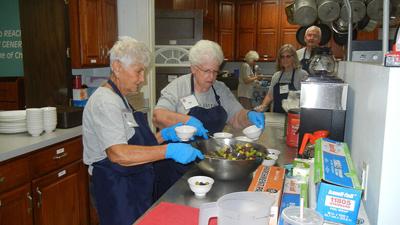From left, volunteers Linda Runzi of Festus and Pat DeClue of Festus help prepare the day’s lunches.