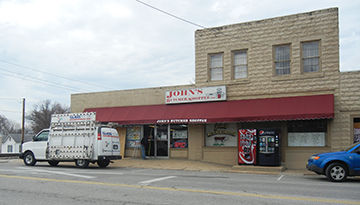 A glass repairman worked to fix a window broken at John's Butcher Shoppee in Festus during a March 8 burglary there.