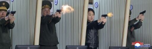 North Korean leader Kim Jong Un's daughter Kim Ju Ae (2nd R) test-firing a new pistol at a shooting gallery at an important munitions factory