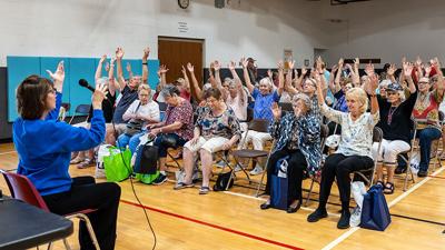 Maureen Menendez, YMCA fitness instructor, leads a chair yoga class during the Festus Senior Expo.