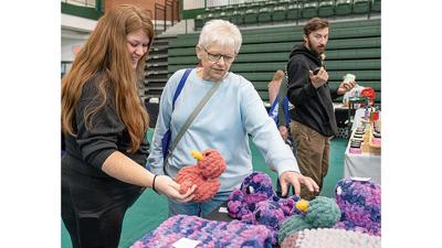 Shoppers browse April 18 through handmade crochet Afghans and animals at the Studio 13 booth at the De Soto Home Show.