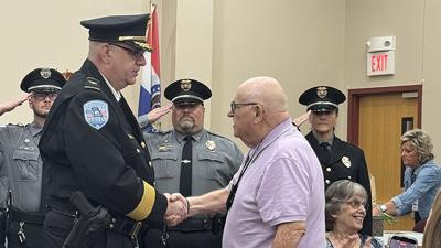 Current Pevely Police Chief Jamie Mayberry shakes hands with former Chief Ron Weeks in a ceremony to name the Pevely Police Station after Weeks.