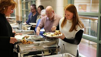 Ward 3 Councilman Rodney Mullins with his wife, Heather, left, and daughter, Reagan, right, go through the food line during the Taste of Arnold event on Nov. 19 at the Arnold Recreation Center.