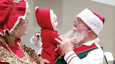 Santa and Mrs. Claus entertain one of the children at the Little Elves Christmas event in De Soto.