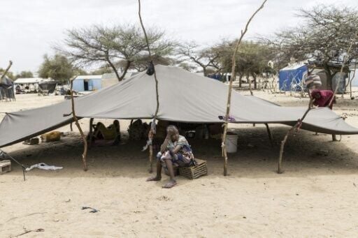 A refugee sits outside a tent at a makeshift camp in Doueinkara, near the Mauritanian border with Mali on April 28, 2026