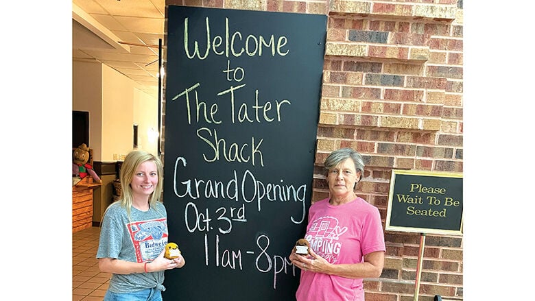 Owner Cheyanne Govro, left, and kitchen manager Chris McKalip hold crocheted “positive potatoes” outside their new restaurant, The Tater Shack.