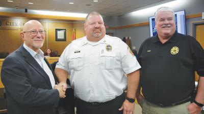 Mayor Sam Richards, left, congratulates Capt. Doug Wendel, center, along with Chief Tim Lewis. Wendel will become chief when Lewis retires May 1, 2023.