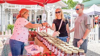 Nikki and Mike Schwab of Imperial buy a jar of Amish strawberry jam from Chris Leach of Imperial at the Kimmswick Strawberry Festival.