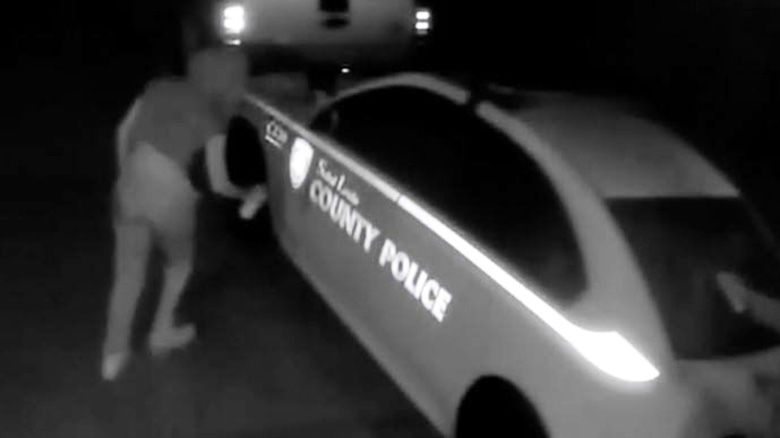 Surveillance footage shows what looks like a woman spray-painting on a St. Louis County Police car.