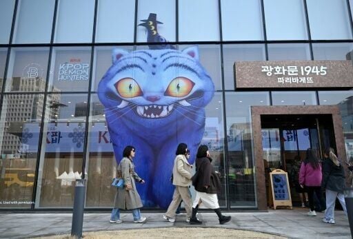 People walk past a glass wall displaying animal characters from Netflix series "Kpop Demon Hunters" at a bakery in Seoul on March 17, 2026