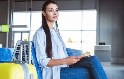 woman waiting in airport with luggage