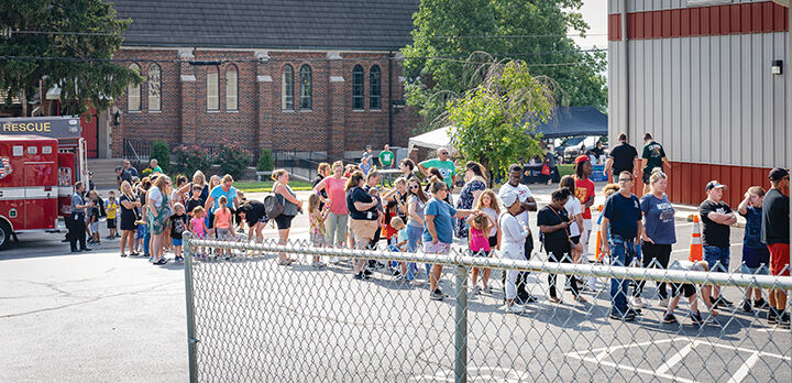Families gather outside Immanuel Lutheran Church to get free school supplies and other items for their children.