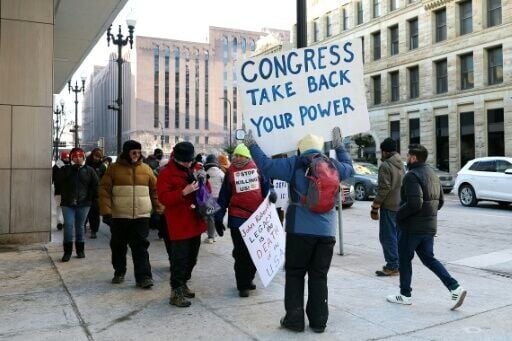 Demonstrators hold signs to protest the presence of federal agents in Minneapolis prior to the start of an NBA game between the Golden State Warriors and Minnesota Timberwolves at Target Center