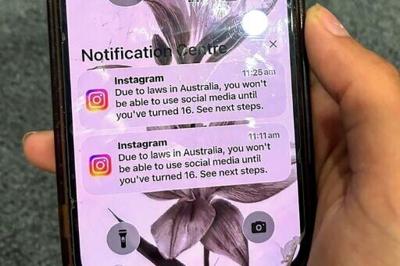 A teenager holds a phone displaying a message from social media platform Instagram after the account was locked for age verification in Australia
