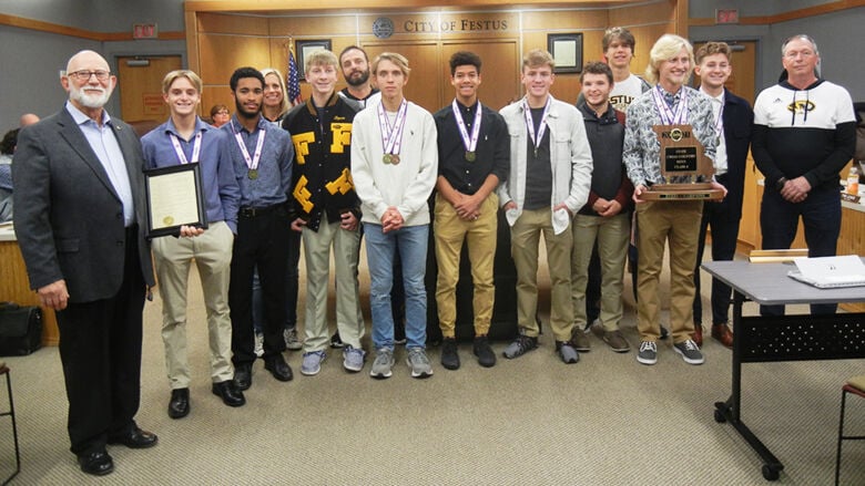 The Festus High boys team receives its proclamation from Festus Mayor Sam Richards (at far left). Head coach Bryant Wright is at far right.