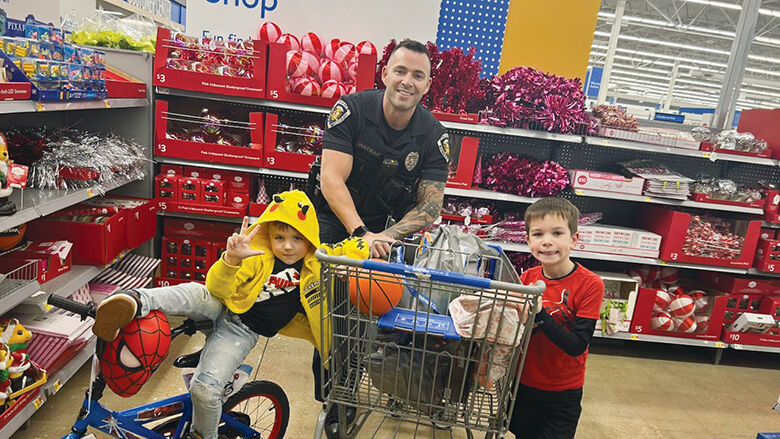 Eureka Police Officer Joshua Hatraf helps two children shop for presents and essentials at the Eureka Walmart.