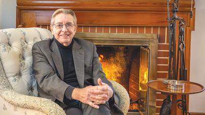 Gordon S. Heddell in front of the fireplace at his Crystal City home. Heddell, who has served as the inspector general for two federal departments, moved back to the area last fall.
