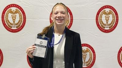 Katie Strawhun holds up her delegate badge at the Congress of Future Medical Leaders at the University of Massachusetts near Boston.
